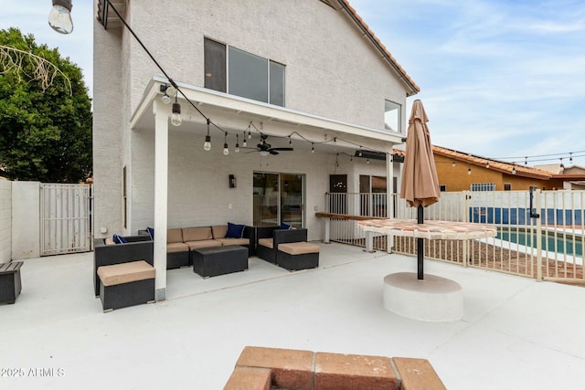 back of property featuring a fenced in pool, a patio area, outdoor lounge area, and ceiling fan