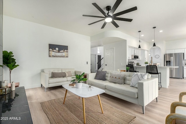 living room with ceiling fan and light hardwood / wood-style flooring