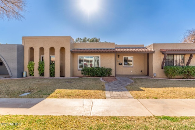 pueblo-style home with a front lawn