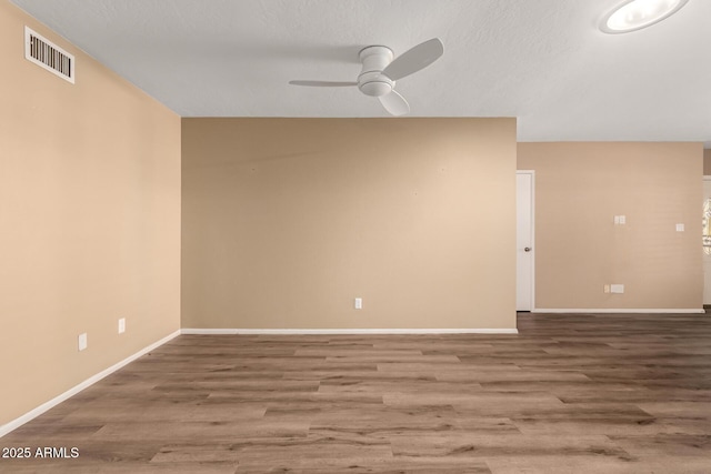 spare room with ceiling fan, wood-type flooring, and a textured ceiling