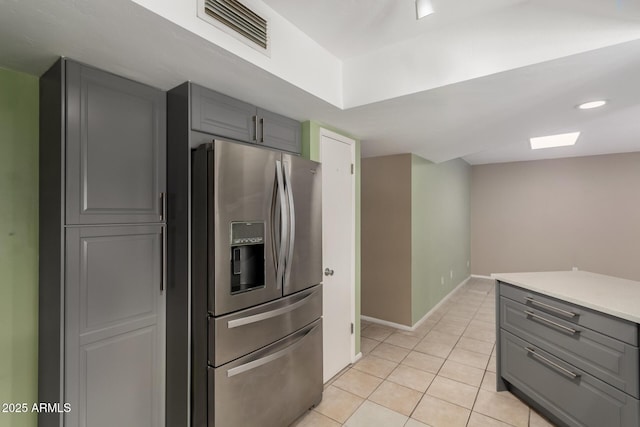 kitchen featuring gray cabinets, stainless steel fridge with ice dispenser, and light tile patterned floors