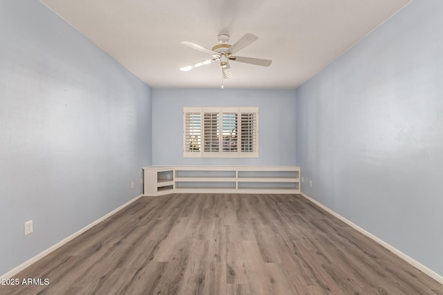 empty room with ceiling fan and hardwood / wood-style flooring