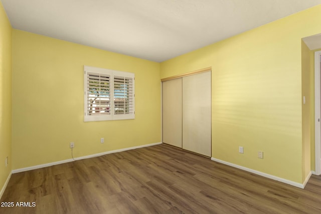 unfurnished bedroom with hardwood / wood-style flooring and a closet