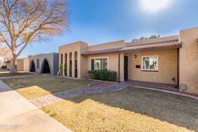 adobe home featuring a front lawn