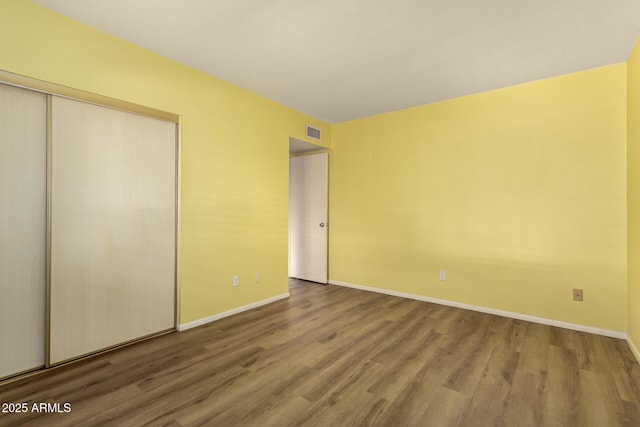 unfurnished bedroom with a closet and hardwood / wood-style floors