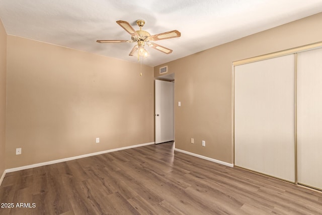 unfurnished bedroom with hardwood / wood-style floors, a closet, and ceiling fan