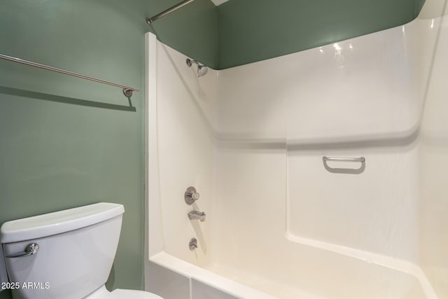 bathroom with tiled shower / bath combo and toilet