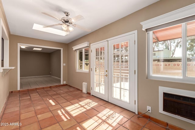 doorway featuring heating unit, ceiling fan, french doors, and light tile patterned floors