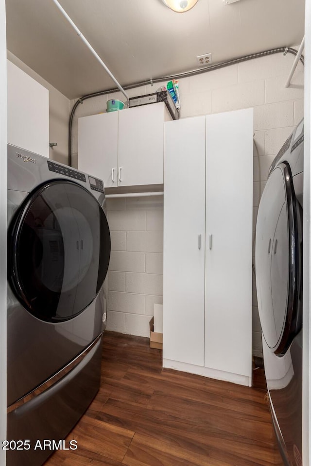 laundry area featuring cabinets, separate washer and dryer, and dark wood-type flooring