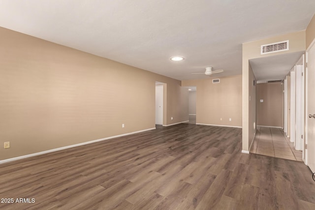 unfurnished room featuring ceiling fan and dark wood-type flooring