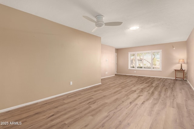 empty room featuring ceiling fan and light hardwood / wood-style flooring