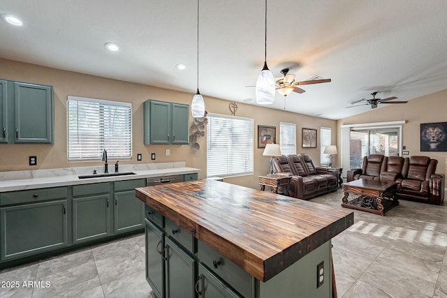 kitchen with a wealth of natural light, butcher block countertops, sink, a center island, and green cabinetry