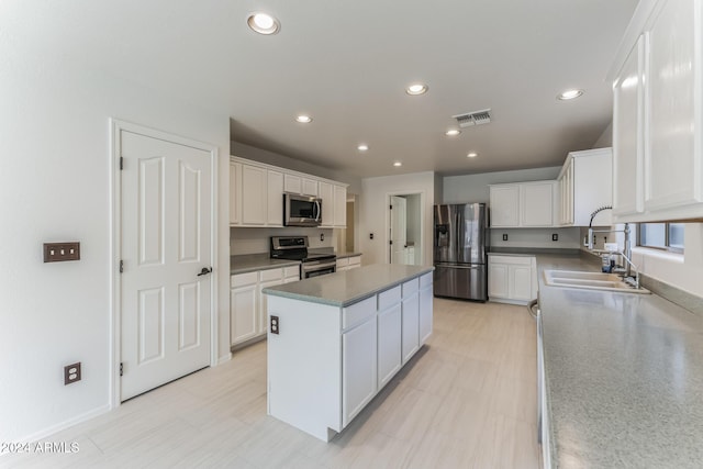 kitchen featuring white cabinets, stainless steel appliances, and a kitchen island