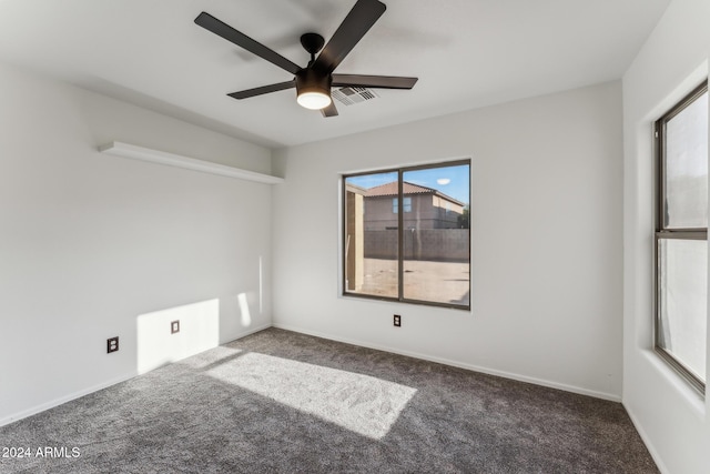 empty room featuring ceiling fan and dark carpet