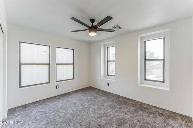 carpeted spare room featuring ceiling fan