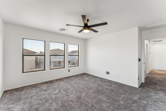 empty room with ceiling fan and dark colored carpet