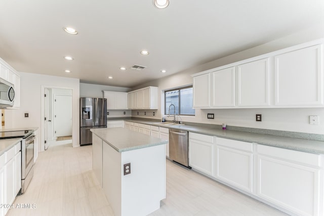 kitchen with white cabinets, sink, a kitchen island, and stainless steel appliances