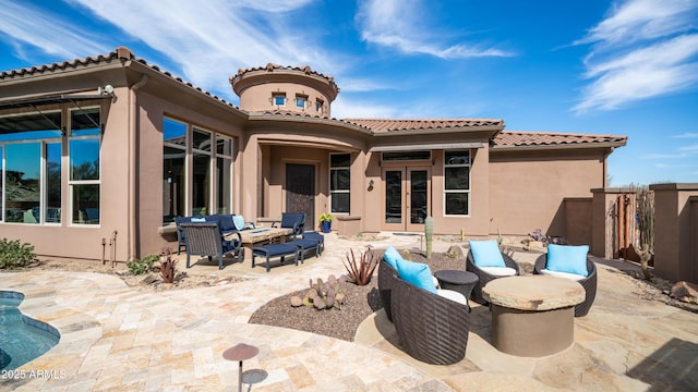 back of property featuring a patio area, french doors, and an outdoor living space with a fire pit