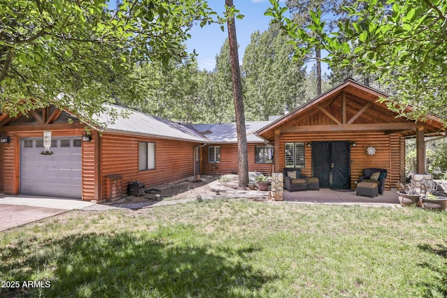 view of front of property featuring a garage, metal roof, and a front lawn