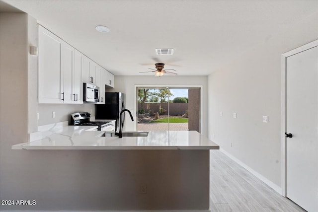 kitchen featuring white cabinets, light hardwood / wood-style floors, stainless steel appliances, and kitchen peninsula