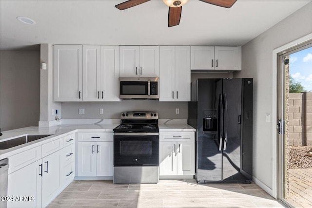 kitchen with stainless steel appliances, white cabinetry, ceiling fan, and sink