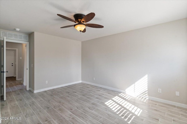 empty room with ceiling fan and light hardwood / wood-style flooring