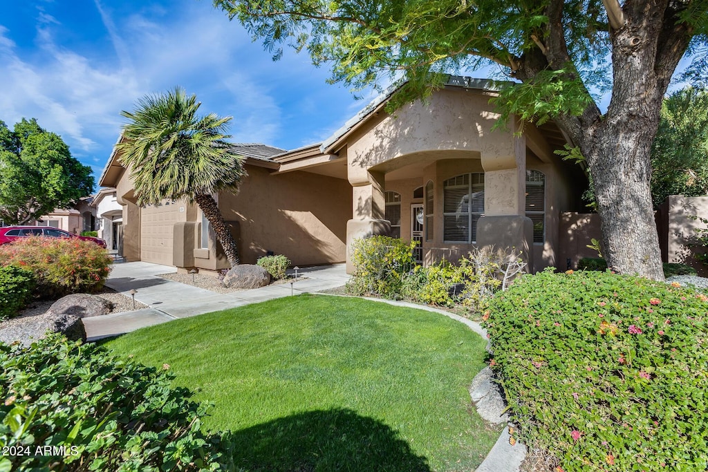 view of front of home with a front yard and a garage