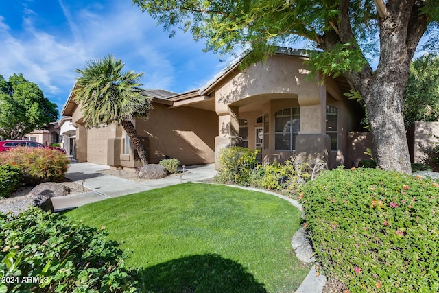 view of front of home with a front yard and a garage