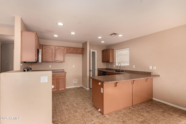 kitchen featuring light brown cabinetry, kitchen peninsula, and sink