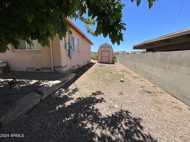 view of yard with a fenced backyard, a storage unit, and an outdoor structure