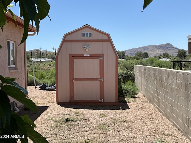 view of shed with fence and a mountain view