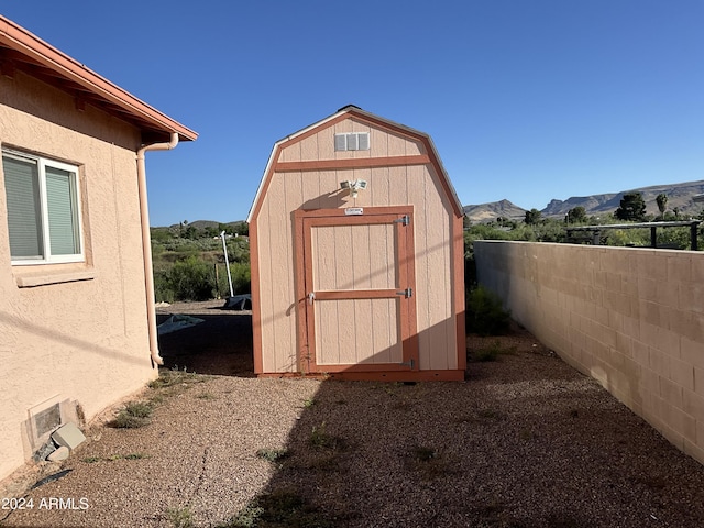 view of shed featuring a mountain view and fence