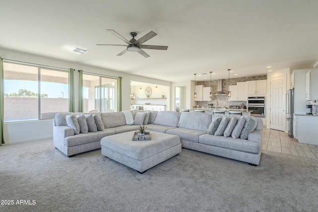 carpeted living room with ceiling fan