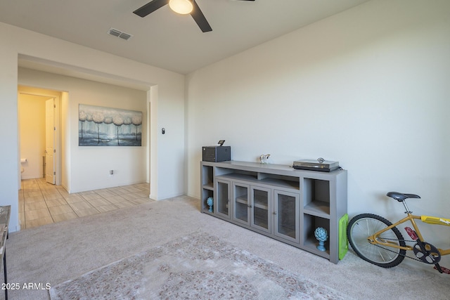 interior space with ceiling fan and light carpet