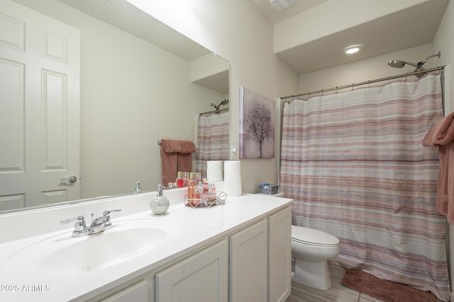 bathroom with toilet, vanity, and a shower with shower curtain