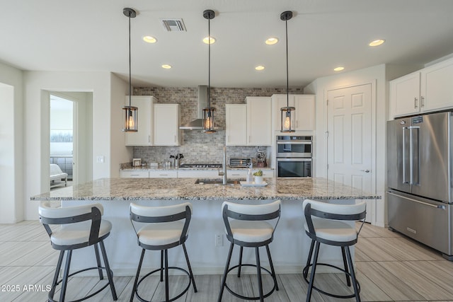 kitchen with a kitchen island with sink and appliances with stainless steel finishes