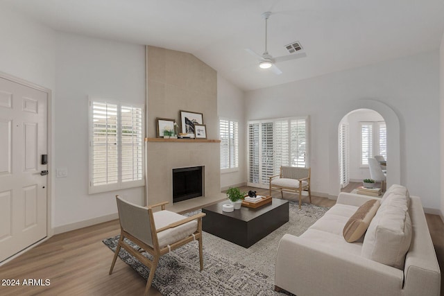 living room with ceiling fan, plenty of natural light, lofted ceiling, and light hardwood / wood-style flooring