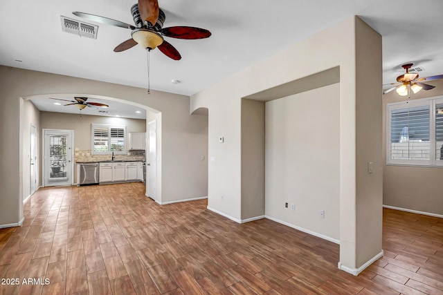 unfurnished living room with sink and ceiling fan