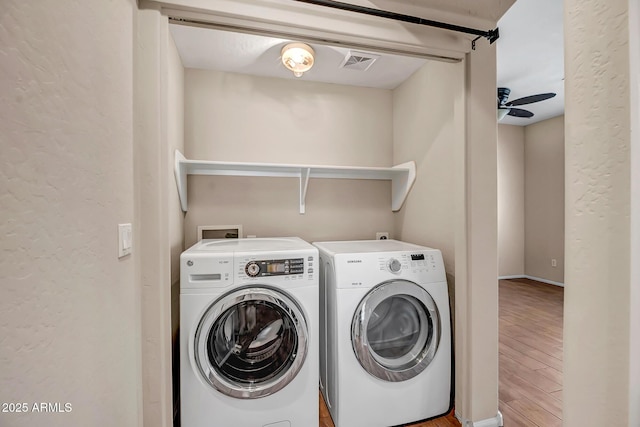 laundry room with ceiling fan, independent washer and dryer, and light hardwood / wood-style flooring