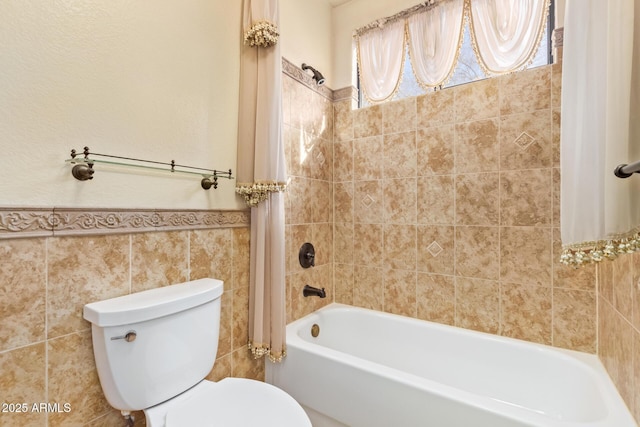 bathroom featuring tiled shower / bath, tile walls, and toilet