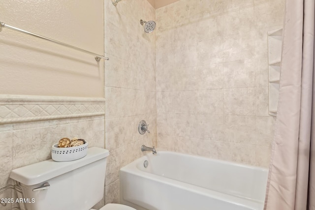 bathroom featuring shower / bathtub combination with curtain, tile walls, and toilet