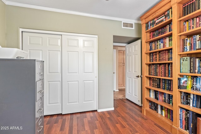 interior space with a closet, ornamental molding, and dark hardwood / wood-style floors