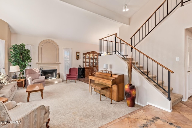 living room featuring beamed ceiling, a towering ceiling, and light carpet