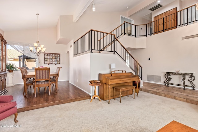 dining room with beamed ceiling, carpet, a notable chandelier, and high vaulted ceiling