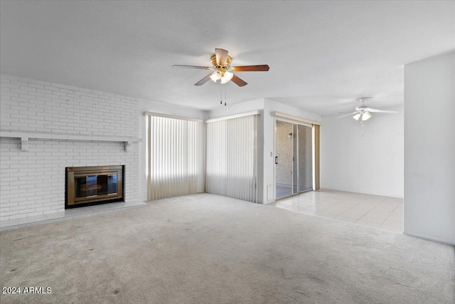 unfurnished living room featuring brick wall, ceiling fan, light carpet, and a brick fireplace