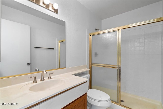 bathroom featuring toilet, walk in shower, and vanity