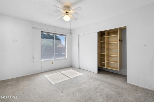 unfurnished bedroom with light colored carpet, a closet, and ceiling fan