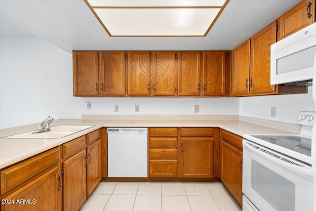 kitchen featuring sink, light tile patterned flooring, a textured ceiling, and white appliances