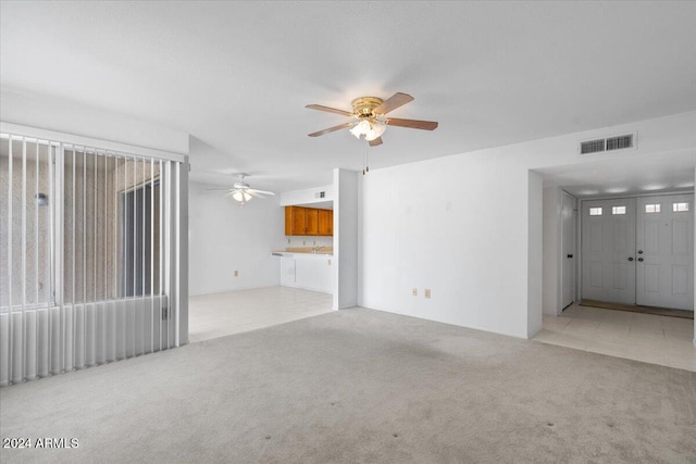 unfurnished living room with ceiling fan and light colored carpet