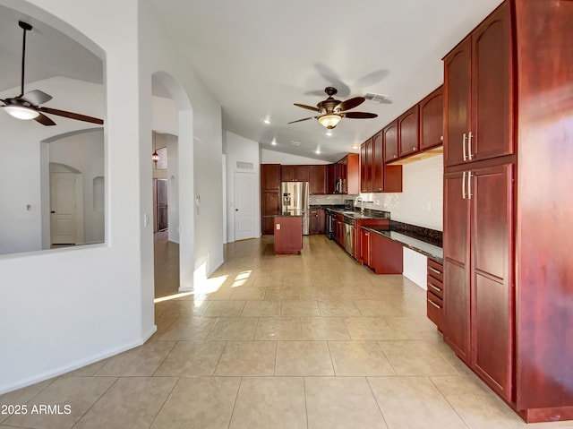 kitchen with lofted ceiling, sink, a center island, ceiling fan, and stainless steel fridge with ice dispenser